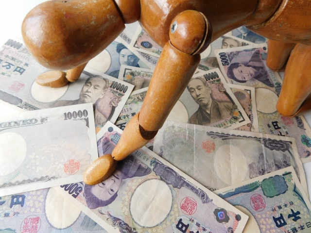 お金の上でうなだれる。小浜市で借金返済の相談は無料でできます